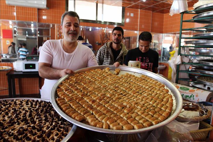 سوري يحول "مرارة" نزوحه لـ"حلوى" في أفواه الغزيين (فيديو)