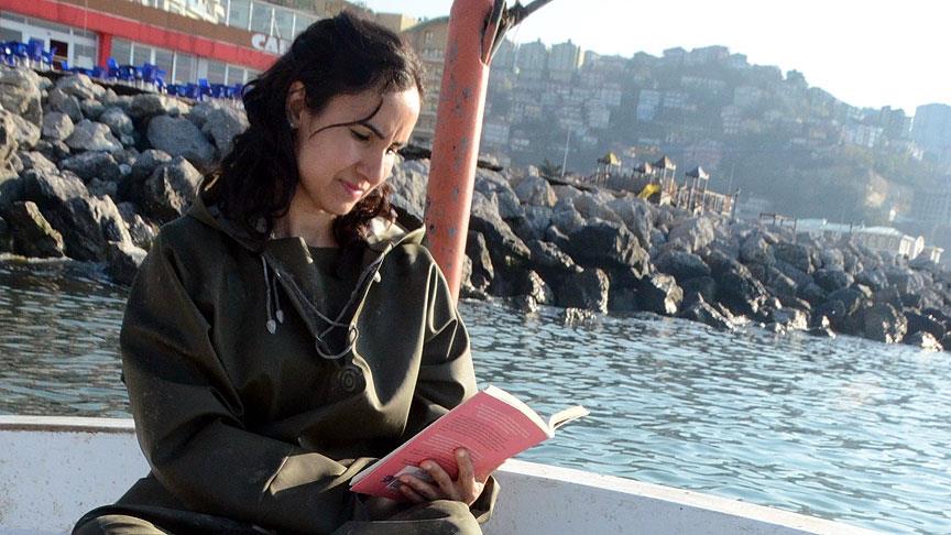 Balıkçı kadın denizde de kitap okuyor