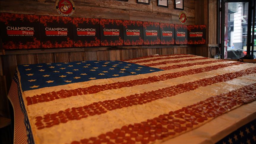 Une pizza géante sous forme de drapeau américain, préparée par un cuisinier turc