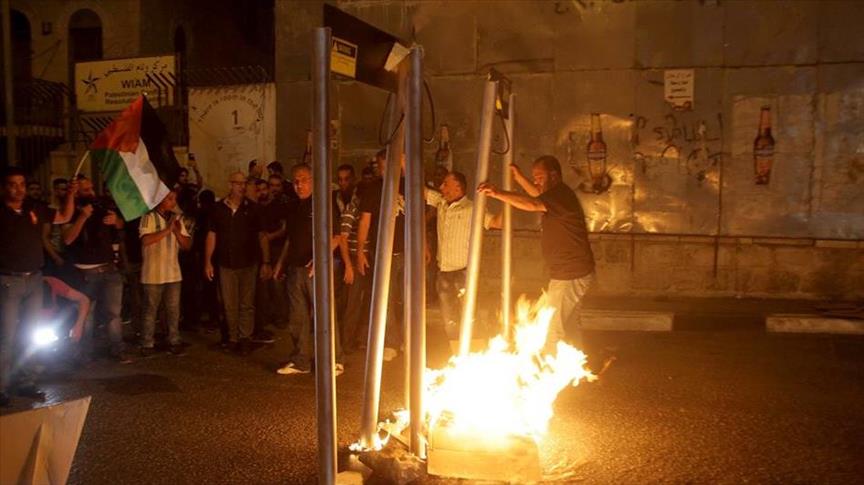 فلسطينيون يحرقون مجسمات لبوابات تفتيش إلكترونية جنوبي الضفة