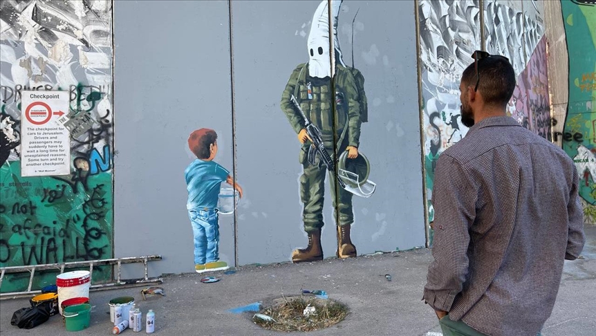 Palestinian graffiti artist paints stories on West Bank barrier