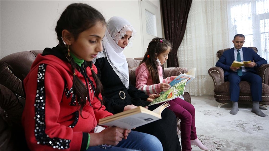 Gönüllü öğretmenler evleri ziyaret edip öğrenci ve velilerle kitap okuyor