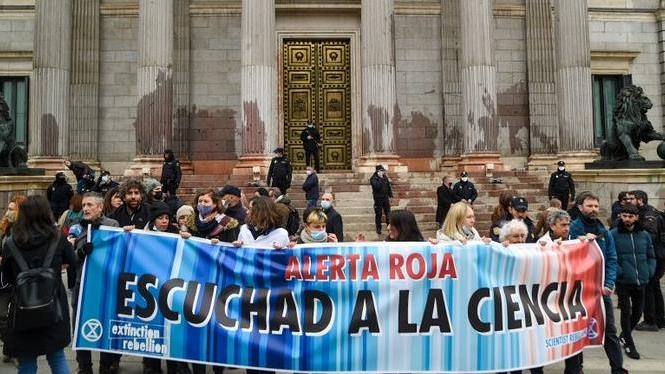 Climate activists cover Spain’s parliament building with red paint