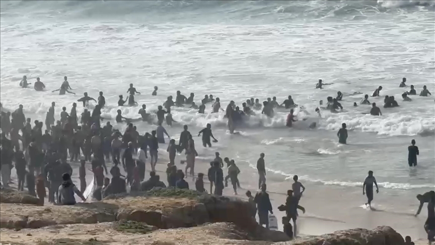 Palestinians in southern Gaza rush to the sea as aircraft drop food aid