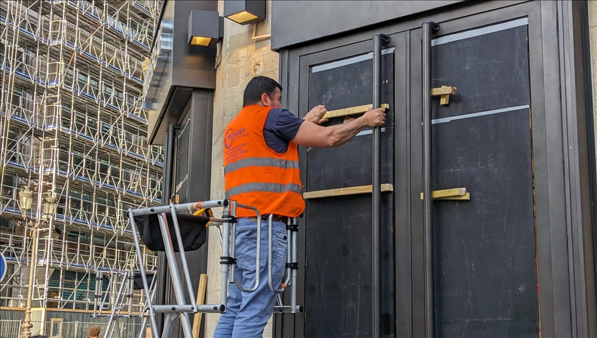 France : les façades de magasins de Paris recouvertes de panneaux de bois afin de prévenir les pillages