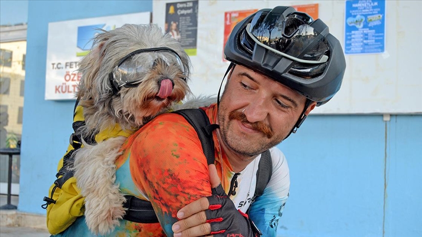 Enkazdan kurtardığı köpeğiyle bisiklet turu yapıyor 