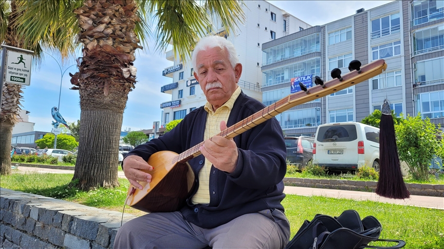 Koyunların peşinde başlayan bağlama sevdasını sahilde küçük konserler vererek sürdürüyor
