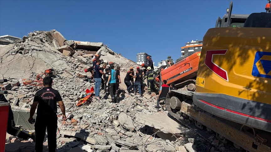 Գş'ta ağır hasarlı bina yıkılırken iş makinesinin üzerine devrildi