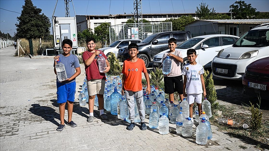 Hatay'daki orman yangınına müdahaleye, konteyner kentteki çocuklardan pet şişeli destek