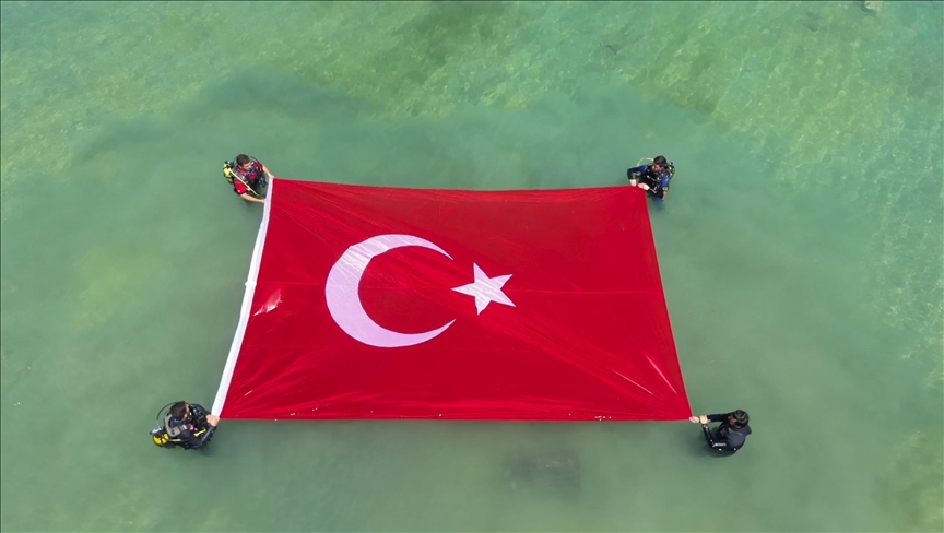 Van'da dalgıçlar Denizcilik ve Kabotaj Bayramı'nı gölde Türk bayrağı açarak kutladı