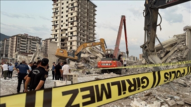 Kahramanmaraş'ta ağır hasarlı bina, yıkılırken iş makinesinin üzerine devrildi