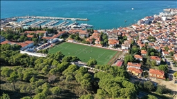 Ağaçların gölgesinde deniz manzaralı tribünde maç keyfi