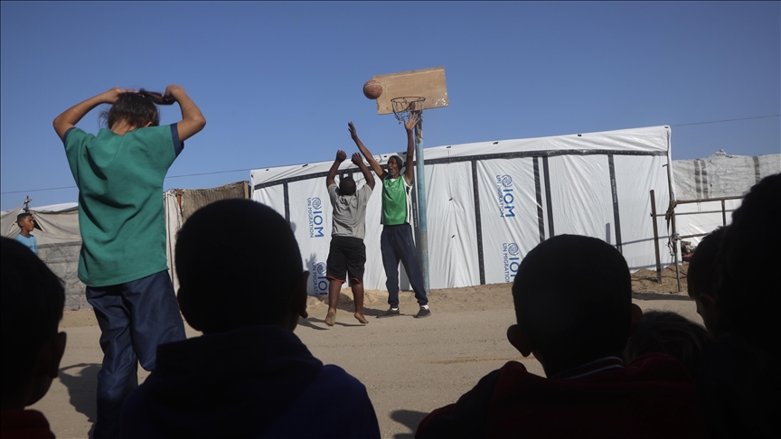 Displaced children in Gaza camp turn sandy road into makeshift basketball court