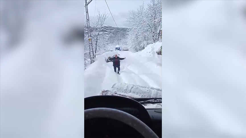 Kar nedeniyle kapanan yolu açılan köy sakini, ekibi oynayarak karşıladı