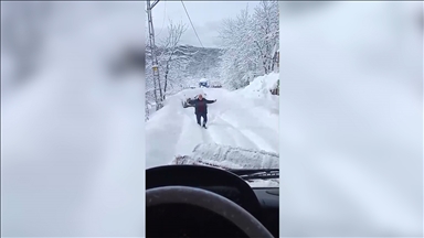 Kar nedeniyle kapanan yolu açılan köy sakini, ekibi oynayarak karşıladı