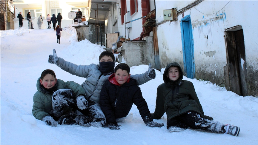 Mahalle yolunu kızak pistine çeviren çocuklar karın tadını çıkardı