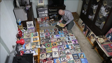 Çocuk yaşta harçlıklarıyla biriktirmeye başladığı binlerce plağına özenle bakıyor