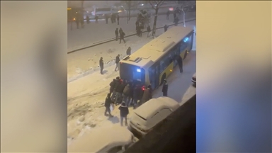 Esenler'de kar nedeniyle yokuşu çıkamayan İETT otobüsünü çevredekilerin itmesi kamerada