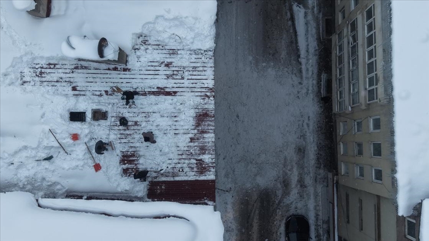 Muş'ta işçiler bellerine bağladıkları iple çatılarda kar temizliği yapıyor