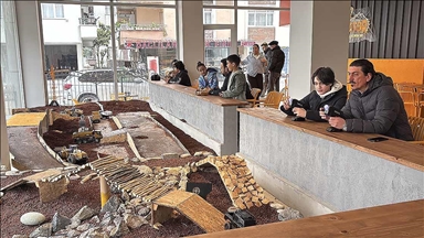 Bu kafenin müşterileri, minyatür inşaat sahasında iş makineleriyle oynuyor