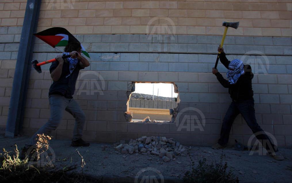 Palestinians make a hole in the Israeli West Bank barrier