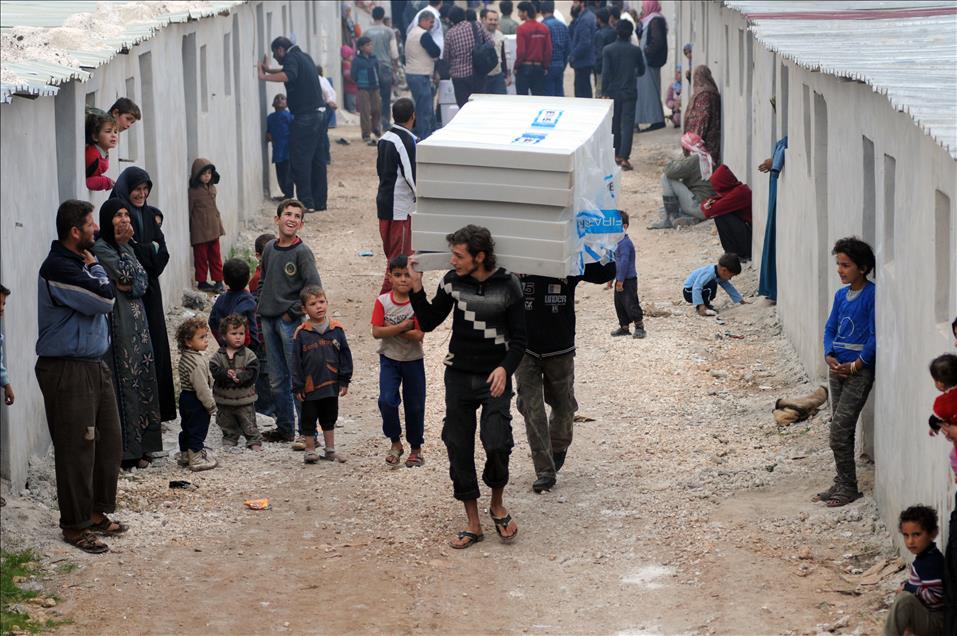 Hayrat Humanitarian Aid Association members set up a village by Syrian families