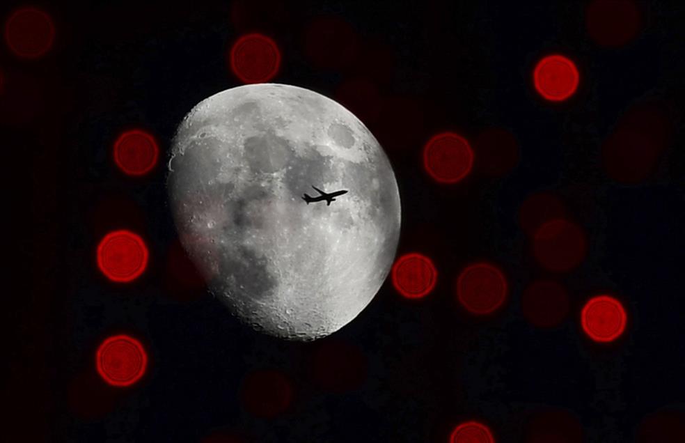 Moon, plane and city lights