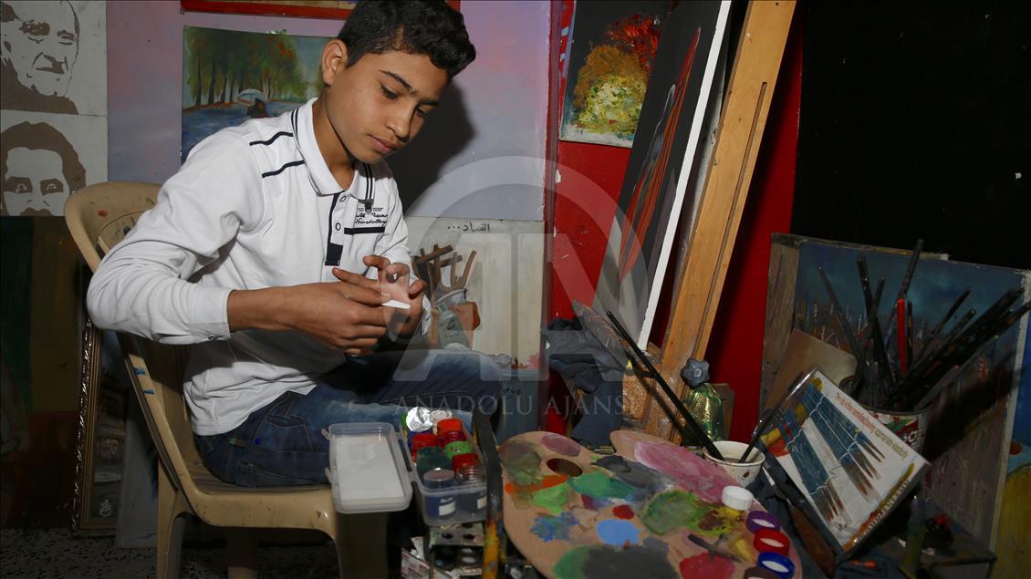 BAGHDAD, IRAQ - MARCH 26 : An Iraqi boy paints a paper on a pane