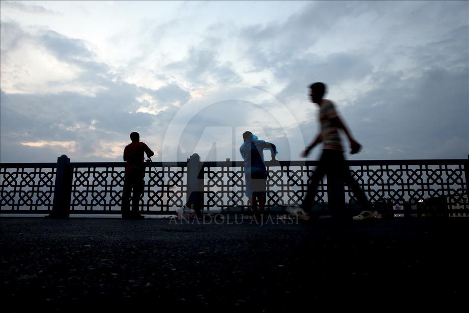 Fishing on Istanbul's Galata Bridge at sunrise