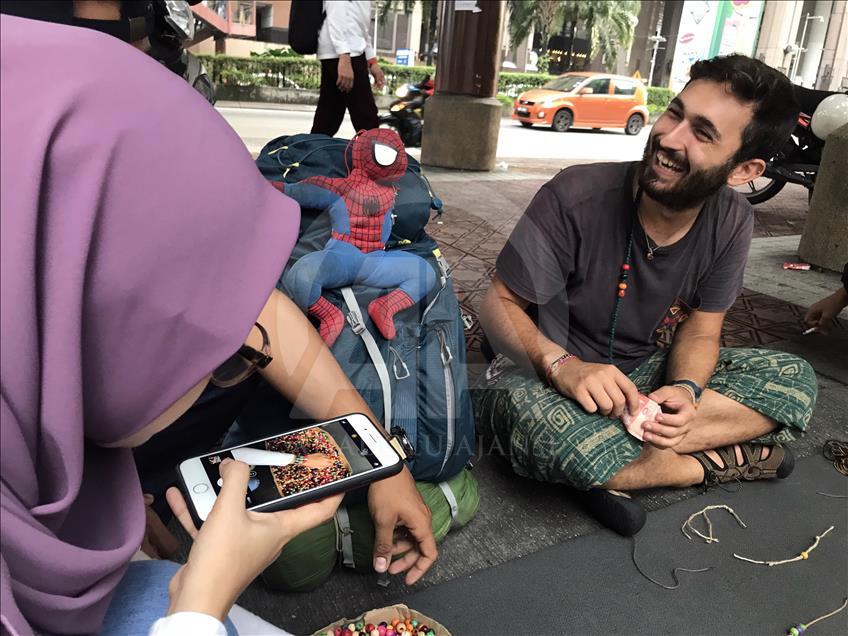 Bileklik satarak dünyayı geziyor