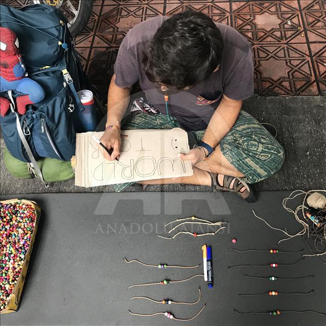 Bileklik satarak dünyayı geziyor
