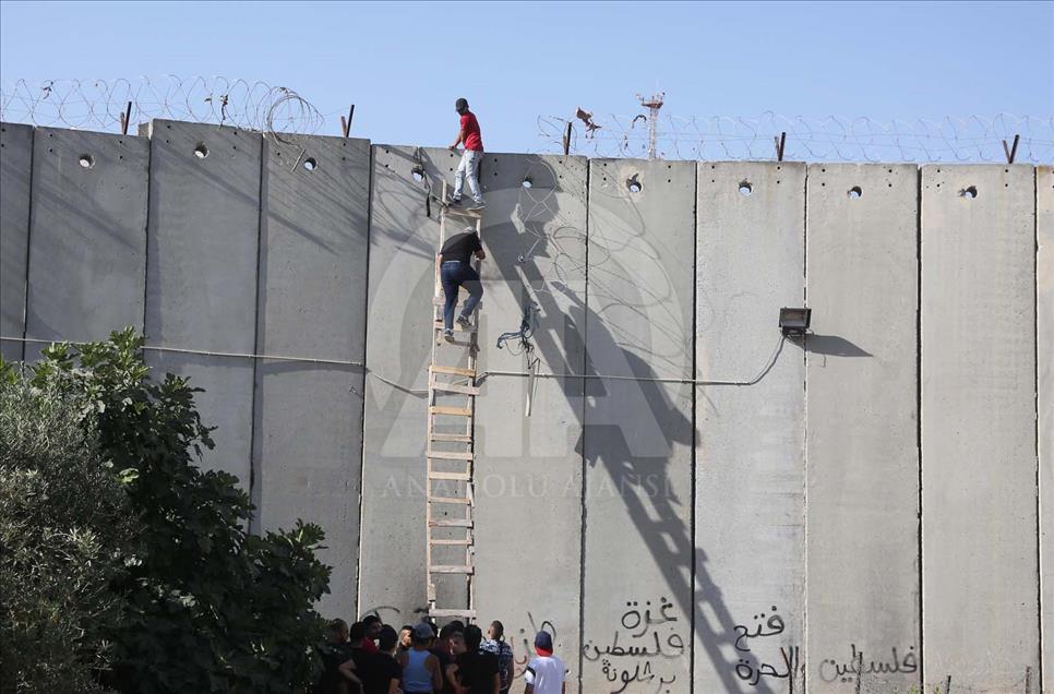 Con escaleras palestinos cruzan el muro hacia Jerusalén para hacer oración del Ramadán