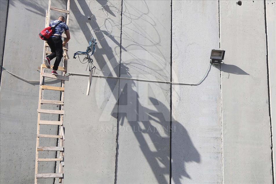 Con escaleras palestinos cruzan el muro hacia Jerusalén para hacer oración del Ramadán