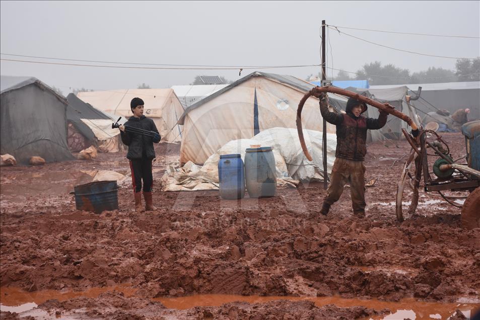 هربا من البرد.. سكان مخيمات إدلب يشعلون النار بأغراضهم
