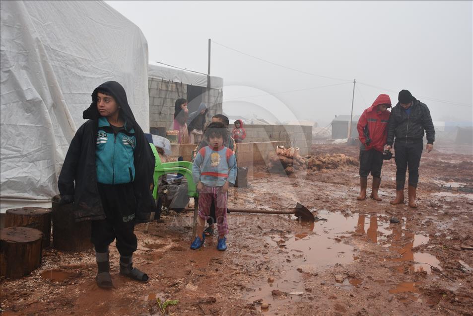 هربا من البرد.. سكان مخيمات إدلب يشعلون النار بأغراضهم
