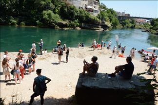 Prvog ljetnog dana turisti u Mostaru traže osvježenje u Neretvi