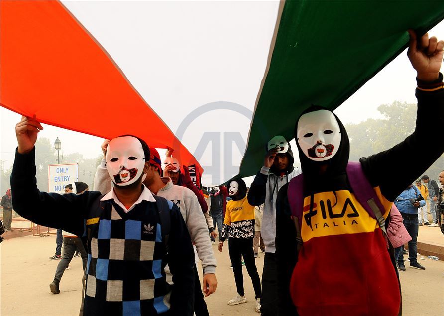 NEW DELHI, INDIA - DECEMBER 30 : Protestors hold tri-colour in front of the India Gate during a protest against the police brutality during the clashes, following days of violent protests across India against a new citizenship law, in  Delhi, India, Decem