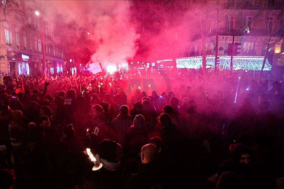 People protest with torchlight in Paris against the pension reform. 
