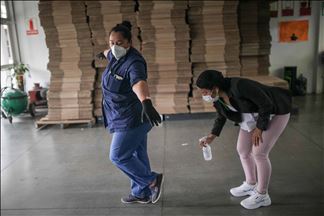 Mujeres pasan de hacer uniformes de policía a confeccionar tapabocas y trajes de bioseguridad