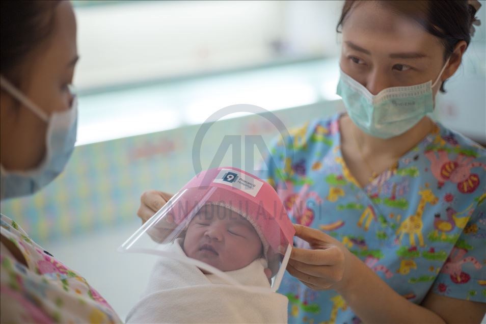 Newborn baby wears a face shield in Bangkok hospital