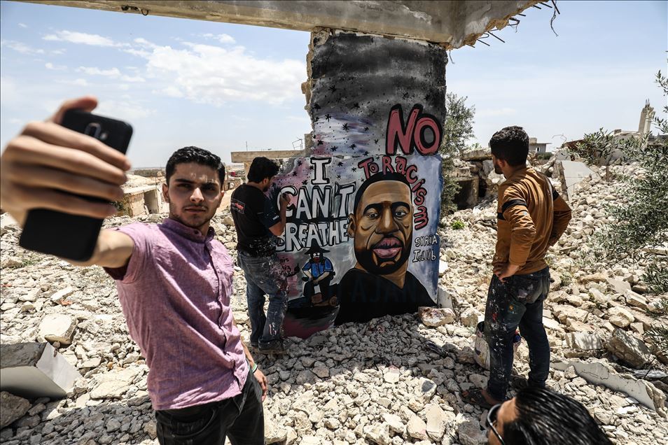 بغرافيتي على جدار قصفه النظام.. فنان سوري يخلد الأمريكي فلويد
