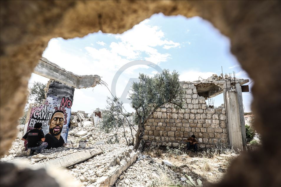 بغرافيتي على جدار قصفه النظام.. فنان سوري يخلد الأمريكي فلويد
