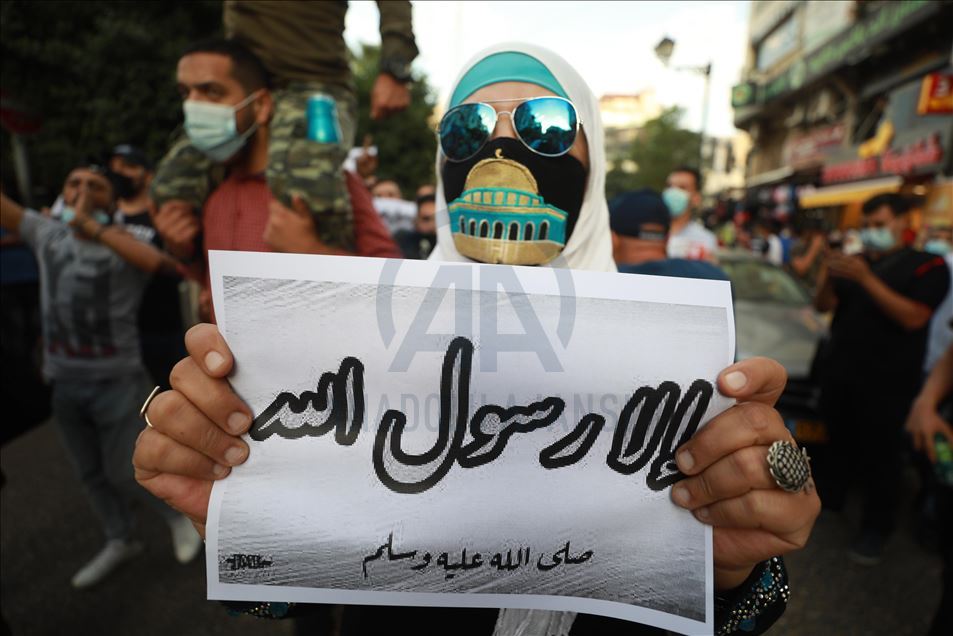 ردا على إساءته للإسلام.. فلسطينيون يحرقون صور ماكرون في الضفة