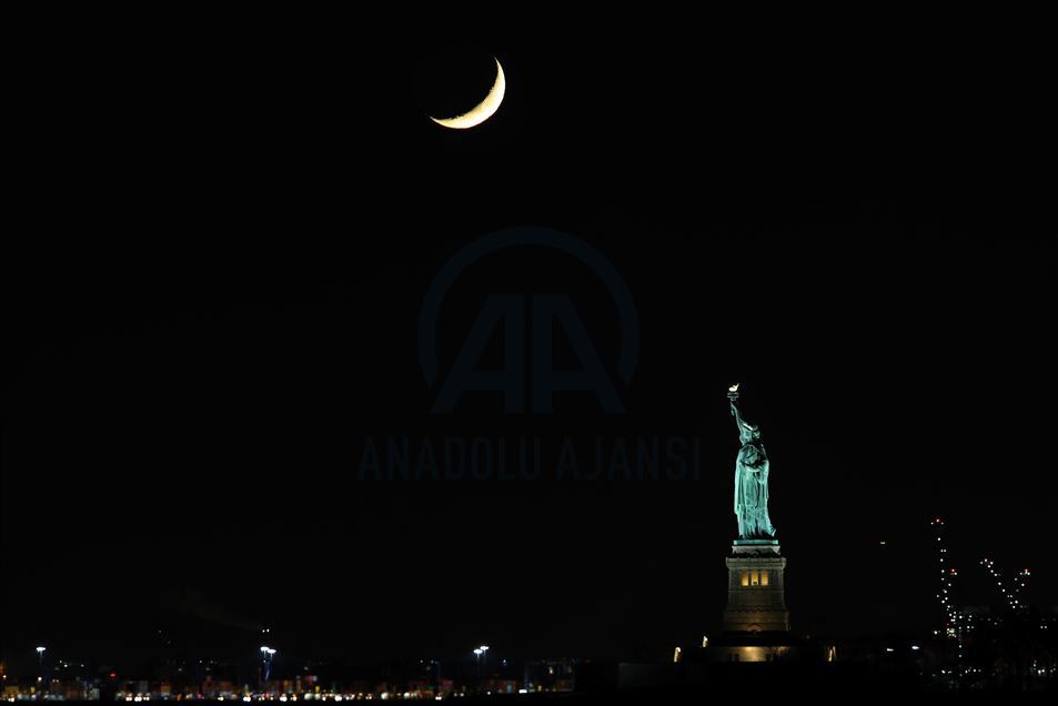 Crescent Moon sets behind the Statue of Liberty in NYC