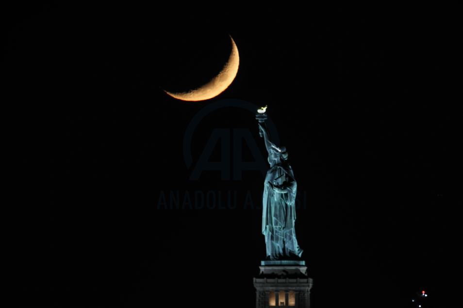 Crescent Moon sets behind the Statue of Liberty in NYC