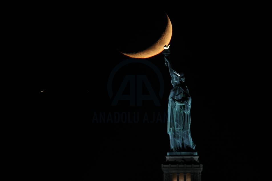 Crescent Moon sets behind the Statue of Liberty in NYC