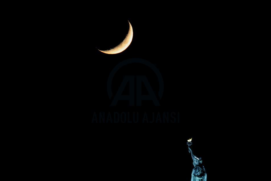 Crescent Moon sets behind the Statue of Liberty in NYC