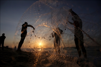 Vida cotidiana de pescadores durante la puesta de sol en las playas de Gaza