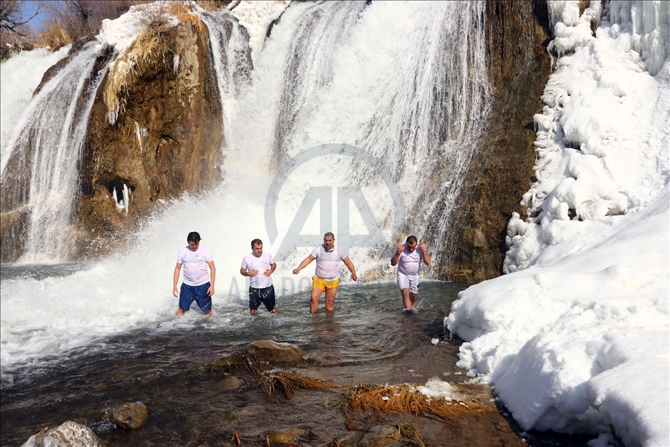Swimming in partly frozen Muradiye Waterfall in Turkey
