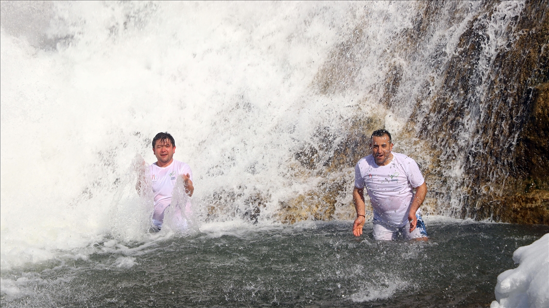 Swimming in partly frozen Muradiye Waterfall in Turkey